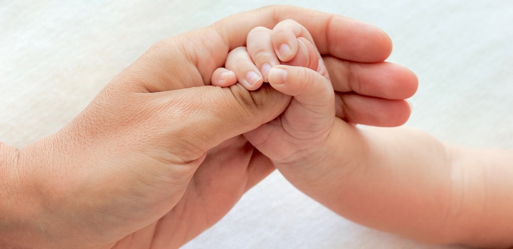 Mother holding baby's hand