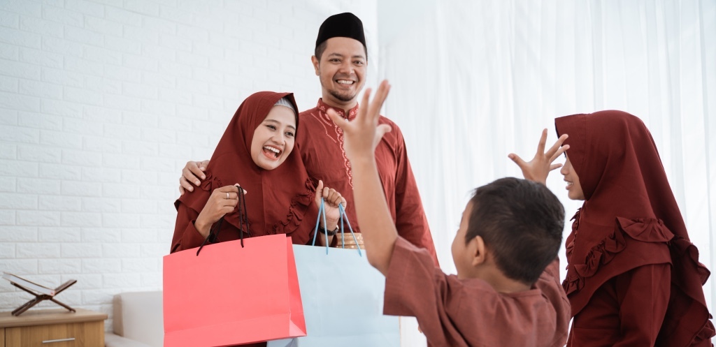 Hijab mother give gifts to their children using paper bags on Eid al-Fitr